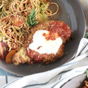 Air Fried Paleo Chicken Parmesan! Crispy, flavorful, and dredged in a low carb breading using almond meal, and coconut flour, this Air Fryer Chicken Parmesan recipe tastes like the real deal, without using oil