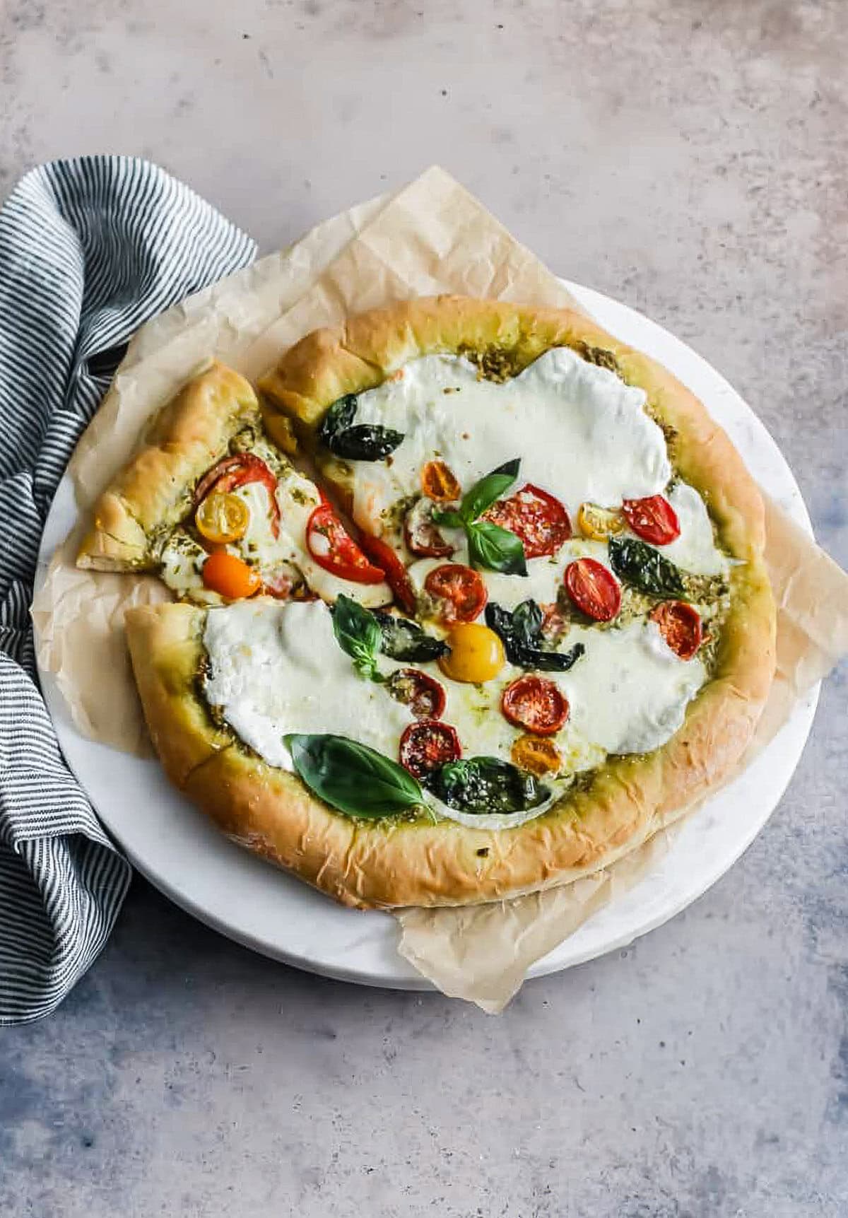 whole pizza with tomatoes, pesto and mozzarella cheese.