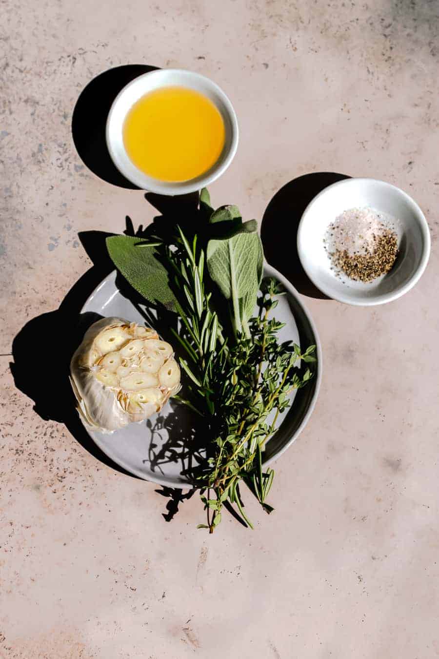 ingredients for rub include minced garlic, fresh sage, thyme and rosemary with salt and pepper and olive oil.