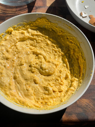 mashed egg yolk filling in a bowl before spooning into egg halves.