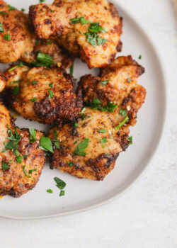 Chicken thighs on a plate with parsley.