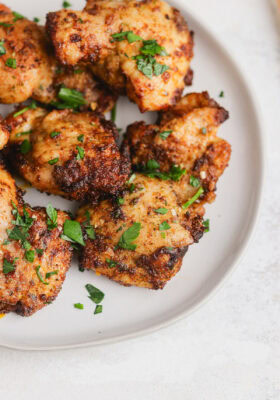 Chicken thighs on a plate with parsley.