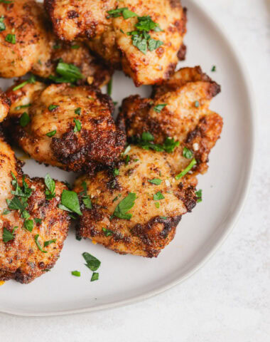 Chicken thighs on a plate with parsley.