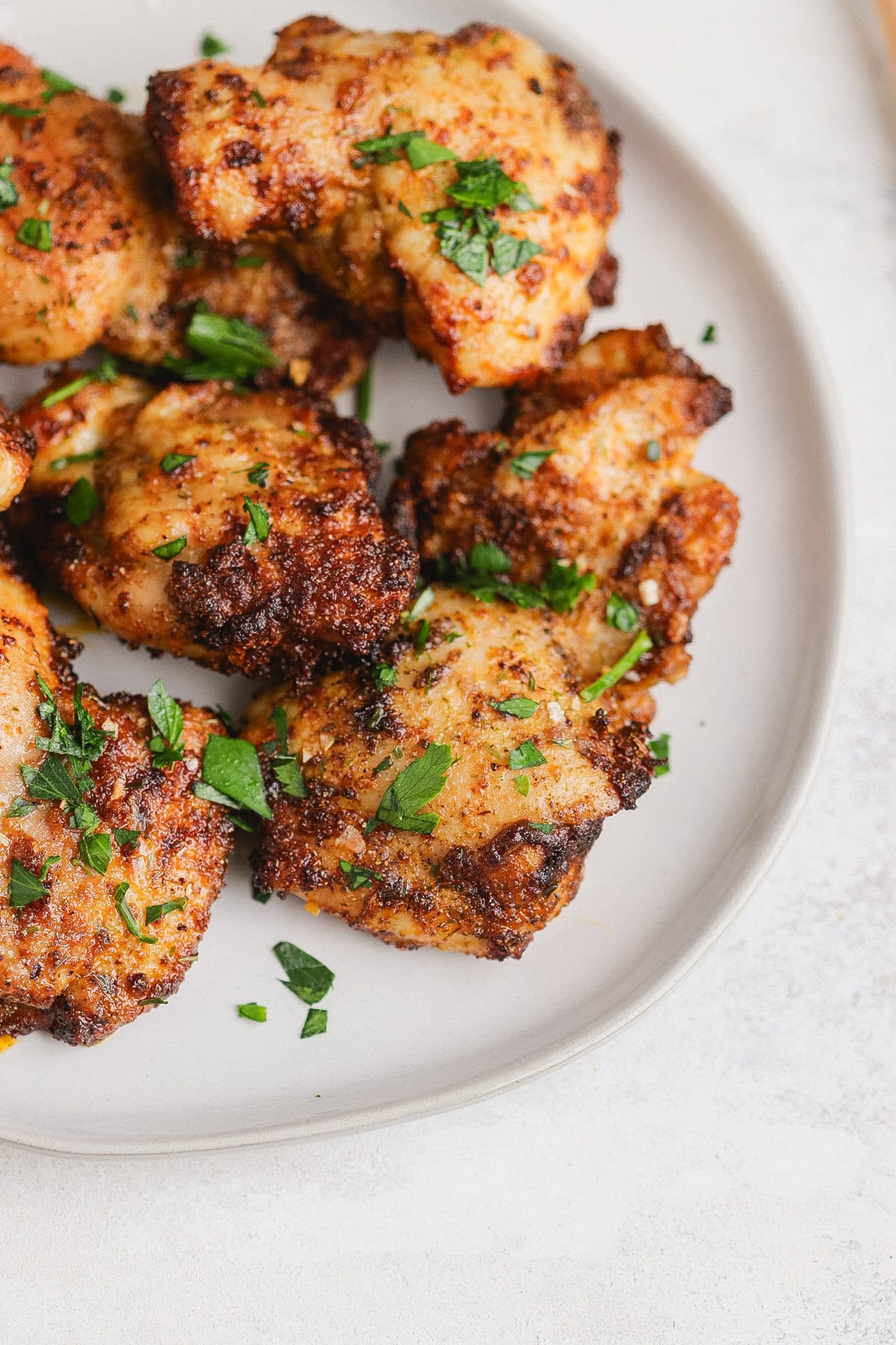 Chicken thighs on a plate with parsley.