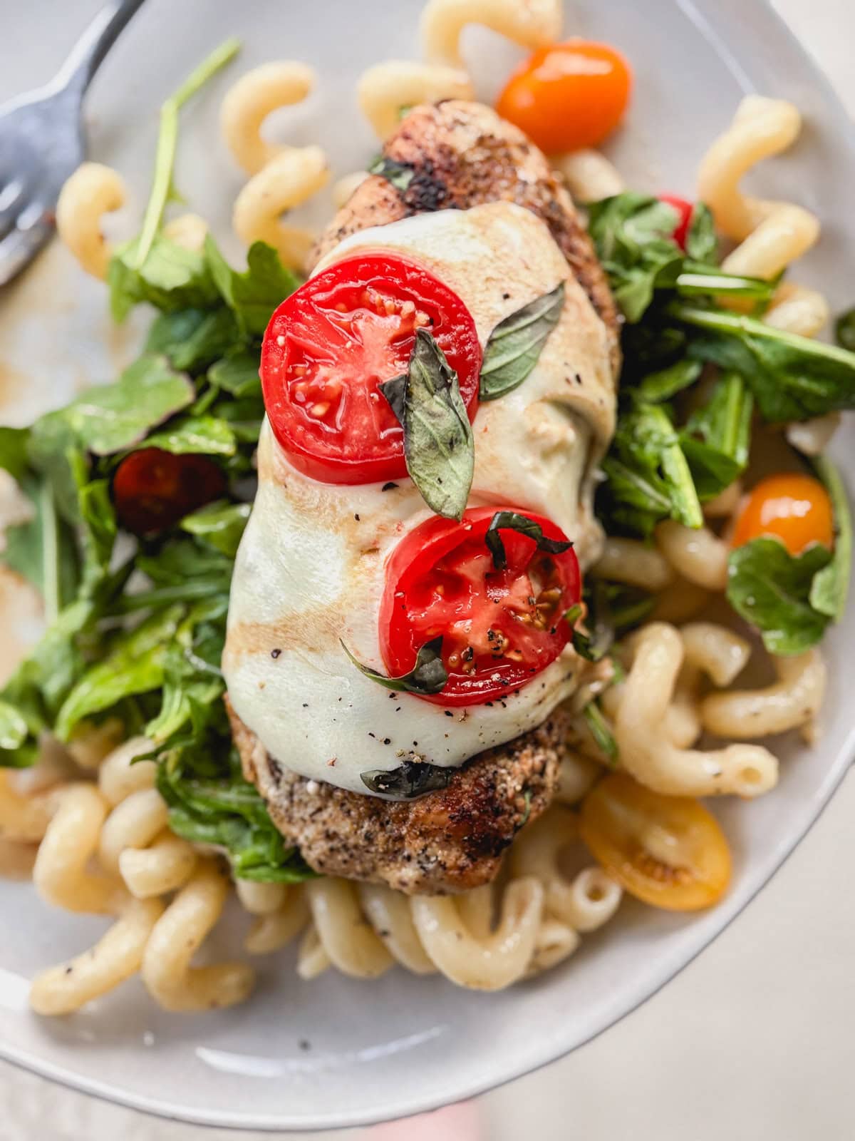 Chicken caprese with basil, arugula pasta.