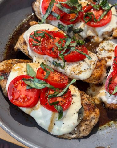 A pan with chicken, mozzarella tomatoes and basil.